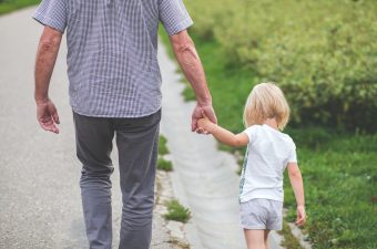 child and adult walking outdoors