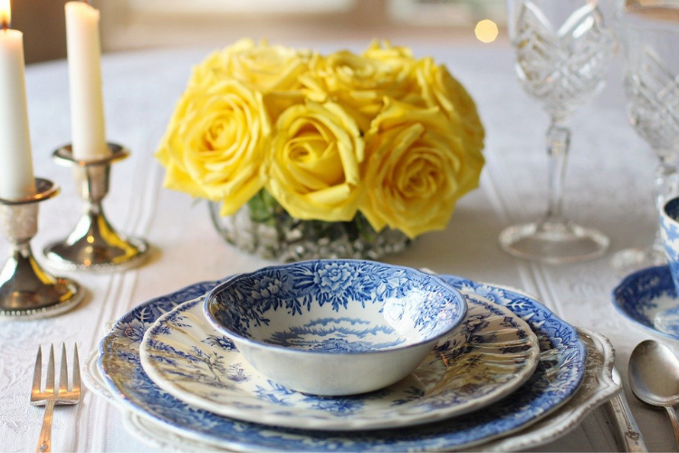 blue and white dishware with yellow flower centerpiece