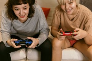 girls playing video games on couch