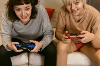 girls playing video games on couch
